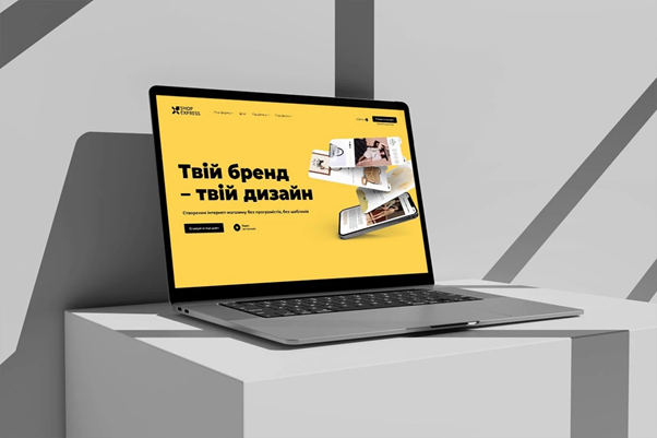 Ноутбук із відкритим сайтом на жовтому фоні з написом 'Твій бренд – твій дизайн'.